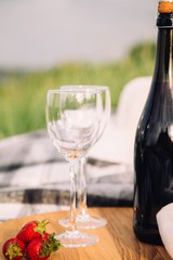 wine bottle with glasses on a wooden board