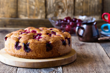 Cherry cake and fresh summer berries on rustic table