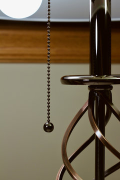 Abstract image of a modern metallic table lamp with pull chain