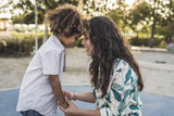 Side view of smiling mother and son touching foreheads outdoors