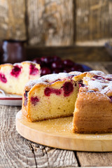 Cherry cake and slice of cake on rustic table
