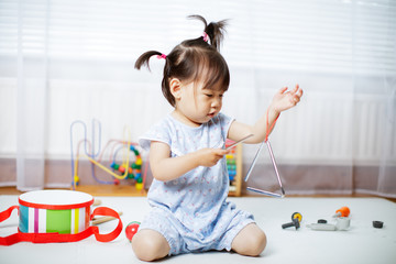 baby girl play triangle at home