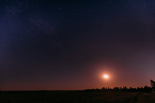 Moonrise Above Summer Meadow Landscape In Starry Night