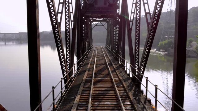 Flying through beautiful railroad train trestle bridge reflected in still waters.
