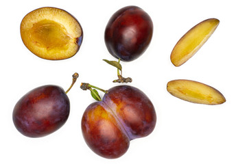 Group of three whole one half two slices of fresh violet-blue plum vibrant moyer variety flatlay isolated on white