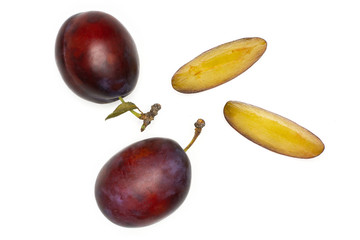 Group of two whole two slices of fresh violet-blue plum vibrant moyer variety flatlay isolated on white
