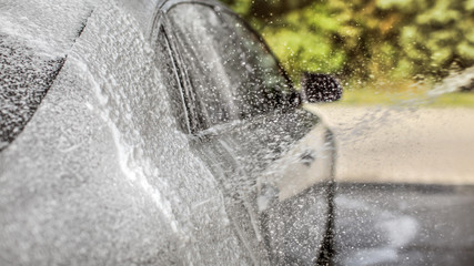Abstract carwash background - only drops in focus. Car being washed at self service station,...