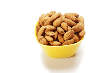 Almonds in yellow bowl isolated on white background 