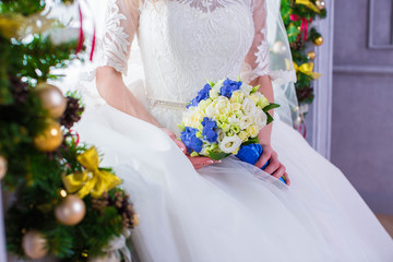 Bride in white wedding dress, holds bouquet of flowers, closeup