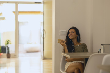 Smiling young woman at the cafe with headphones