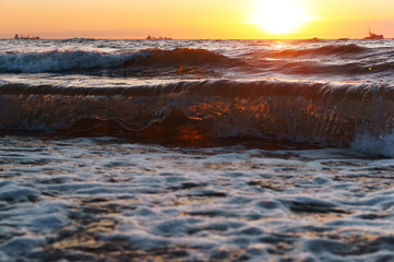 Sunset over the sea. Reflection of sunlight in the sea waves. Red sky in the rays of the sunset.