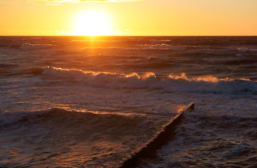 Sunrise in the waves of the sea. Sunset on the sea.