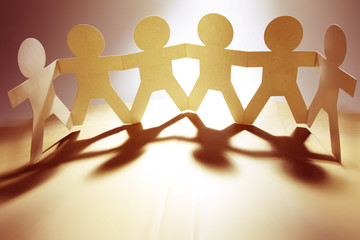 Paper chain team united together holding hands