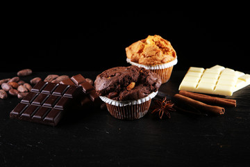 Chocolate muffin and nut muffin, homemade bakery on dark background.