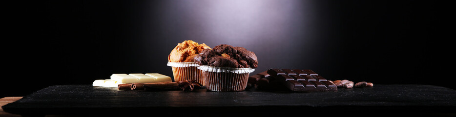 Chocolate muffin and nut muffin, homemade bakery on dark background.
