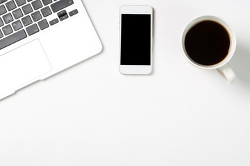 Conceptual workspace or business concept. Laptop computer with cup of coffee and modern mobile phone on white background. Free space for your text