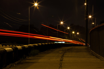 Fototapeta na wymiar traces of car headlights on a night street