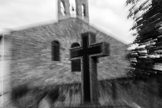 Catholic sign of the cross, Outdoors, near a temple. Technique Zoom in. Converted to black and white, grain added.