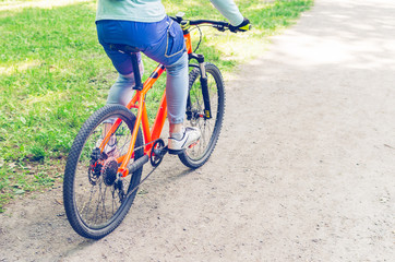 Cyclist on an orange bike riding a bicycle path