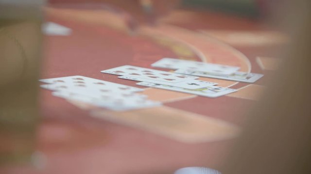Slow motion shot of cards and chips on velvet poker table in casino. Gambling, luck and addiction concept.