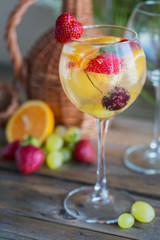 Homemade refreshing fruit sangria or punch with champagne, strawberries, oranges and grapes.