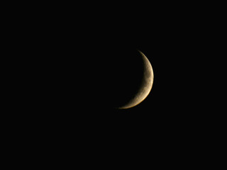Obraz na płótnie Canvas Orange Moon on the night sky in Waxing Crescent Phase, shortly before moonset, illumination 16%, age 3.90 days, on the 16th of July 2018 at 23:10 GMT+3