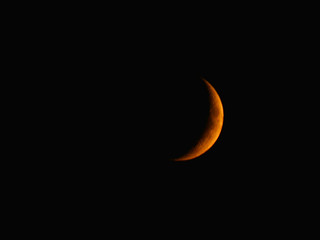 Orange Moon on the night sky in Waxing Crescent Phase, shortly before moonset, illumination 16%, age 3.90 days, on the 16th of July 2018 at 23:10 GMT+3