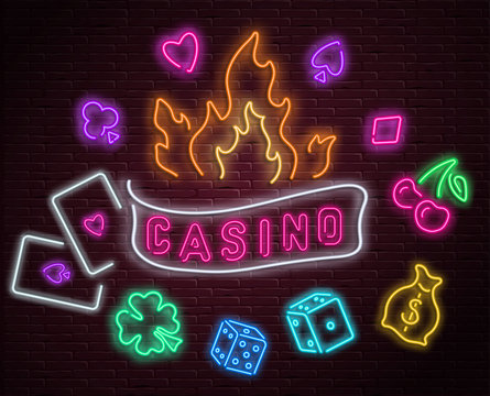 Colorful neon luminous casino signboard on bricklaying wall.