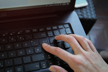 Woman's hand pressing Enter on Laptop