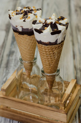 Ice cream cornetto.  Ice cream waffle cone vanilla and chocolate on rustic background