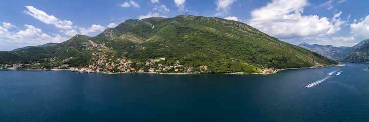 Fototapeta na wymiar Aerial panoramic beautiful view from above to Kotor Bay and regular passenger ferry from Lepetane to Kamenari by a sunny afternoon