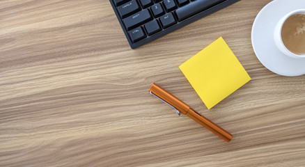 Wooden Desk with Keyboard Pen and Sticky Notes Shot Above