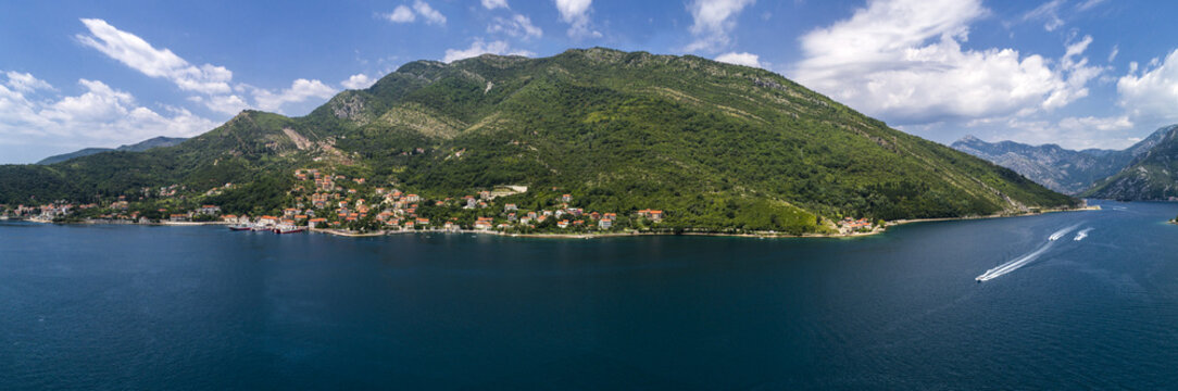 Aerial panoramic beautiful view from above to Kotor Bay and regular passenger ferry from Lepetane to Kamenari by a sunny afternoon