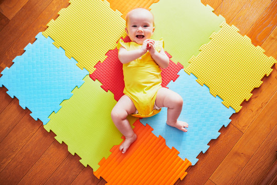 Smiling Baby Girl Lying On Play Mat