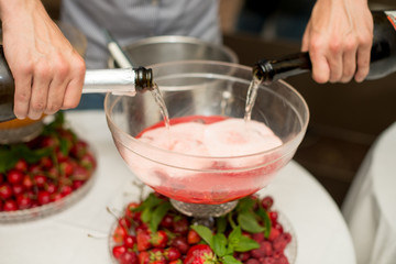 Beverage with ice cubes. Pouring champagne. mint and fruit are out of focus.