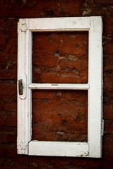 White window frame hanged on red brick wall. Original decoration concept