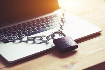 Locked chain on laptop as computer protection and cyber safety concept. Private data protection...