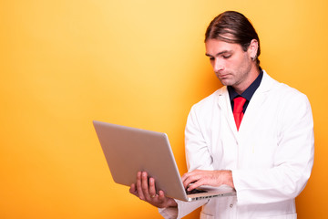 Male doctor holding laptop in his arms