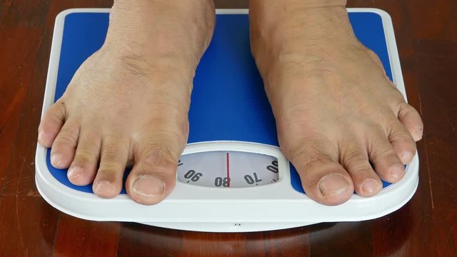  close-up 4K,male measuring weight on health scale
