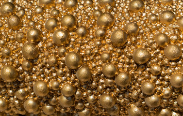 balls of golden color of different size closeup. bright gold shiny background