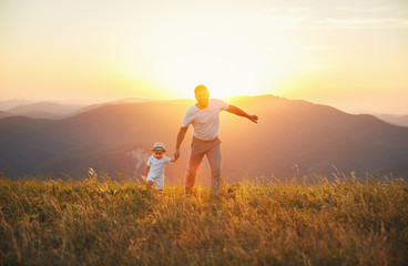 Fototapeta na wymiar Father's day. Happy family father and toddler son playing and laughing on nature at sunset