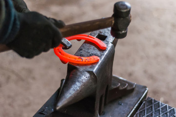 Blacksmith shaping the burning horse shoes