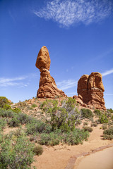 The iconic Balanced Rock stands in sharp relief against an electric blue summer sky in Arches National Park