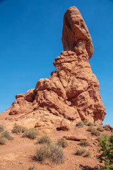 Fototapeta na wymiar The iconic Balanced Rock stands in sharp relief against an electric blue summer sky in Arches National Park