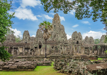 Ancient temple Bayon Angkor complex with stone faces of buddha Siem Reap on blue sky cloudy, Cambodia