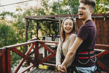 Excited young couple preparing for ride on zip line