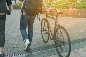 Naklejka premium Man walking with bicycle on path way with sunlight vintage color tone style background