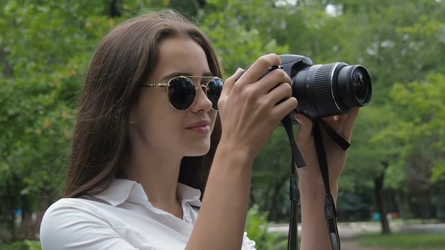 Beautiful girl with a camera. Teen girl with a camera in the park.