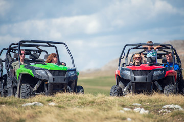 Friends driving off-road with quad bike or ATV and UTV vehicles