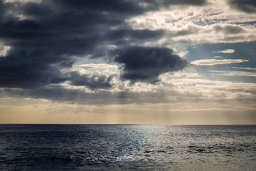 Naklejka na ściany i meble Evening view with sun shining throug clouds at Makua beach, Oahu, Hawaii